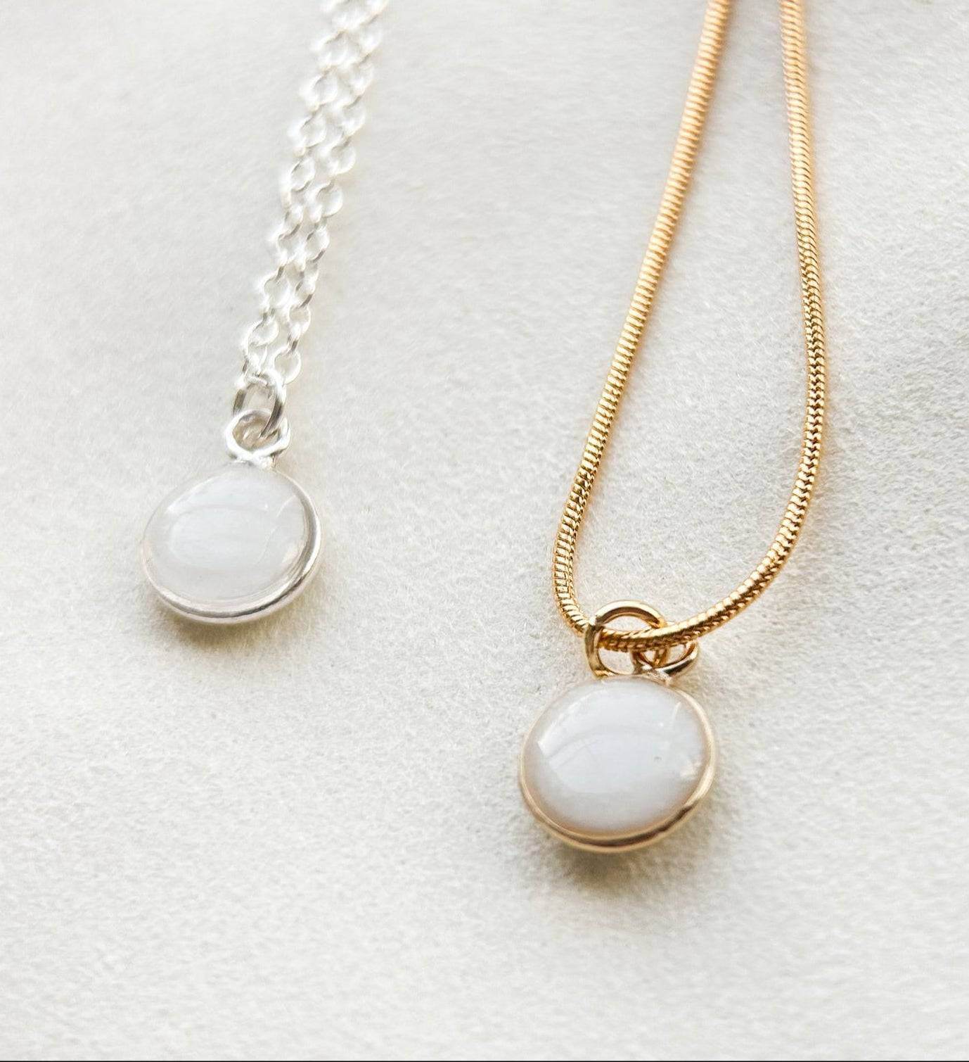 Breastmilk jewelry in a ball with gold or silver chain.