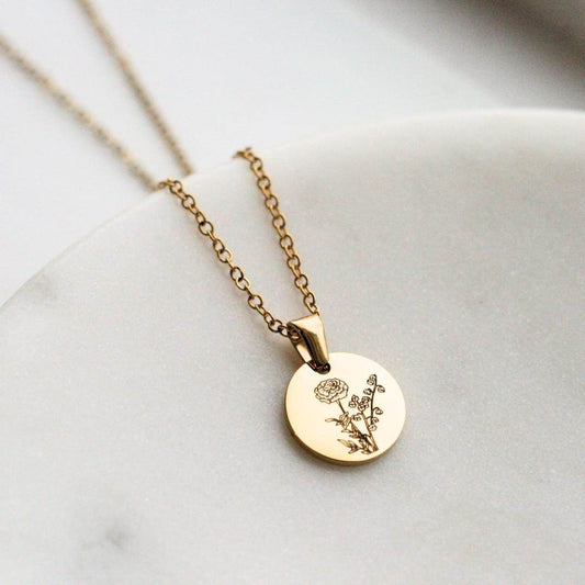 A gold birth month flower necklace engraved with two flowers