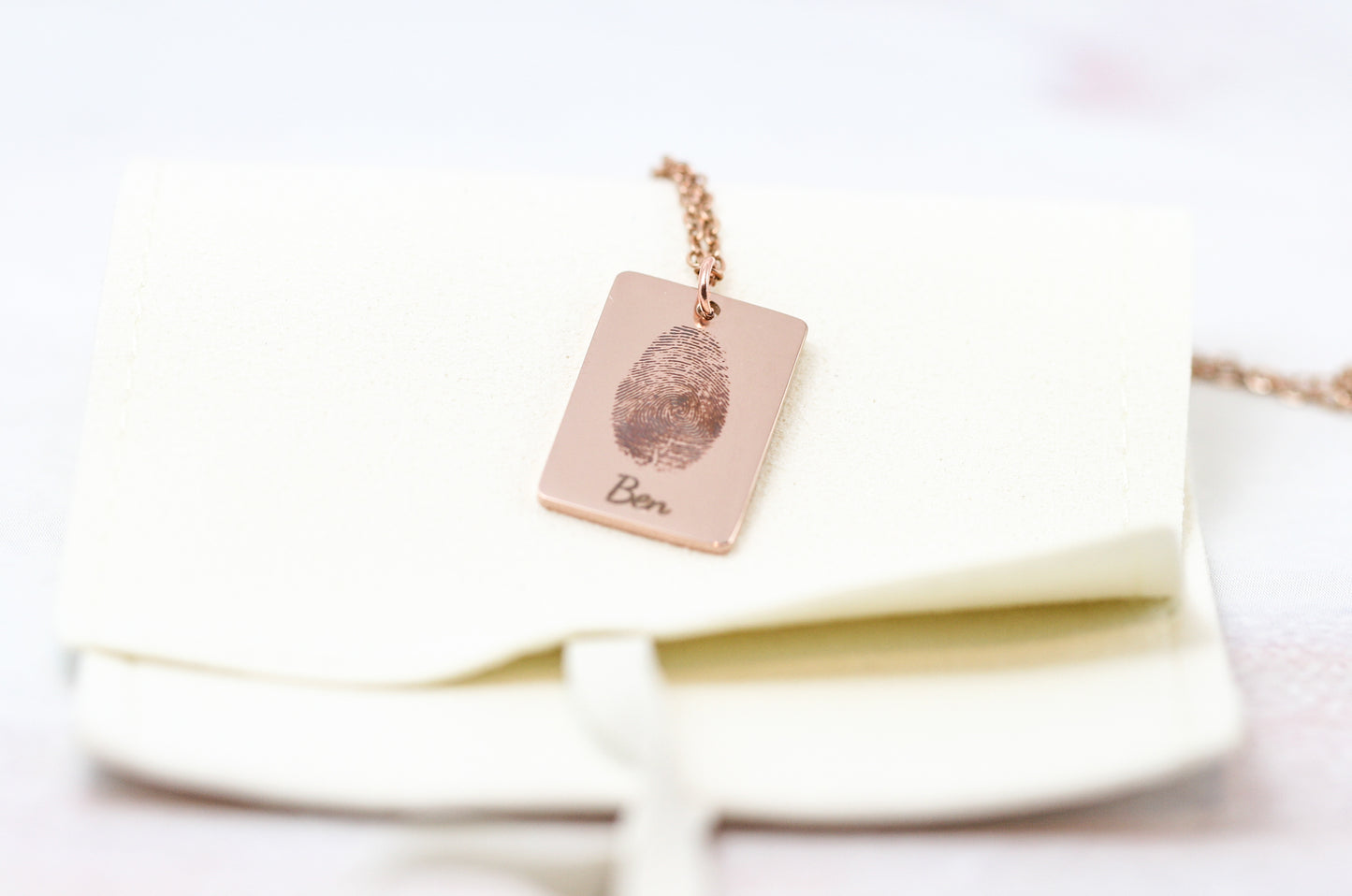 rose gold fingerprint necklace on white storage pouch