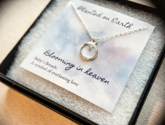 one piece of babys breath in a sterling silver pendant necklace with a necklace card reading "planted on earth blooming in heaven"