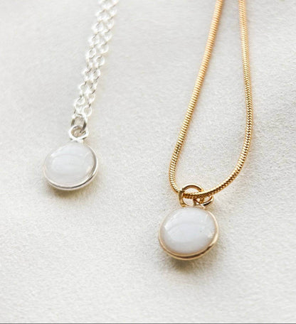 Breastmilk jewelry in a ball with gold or silver chain.