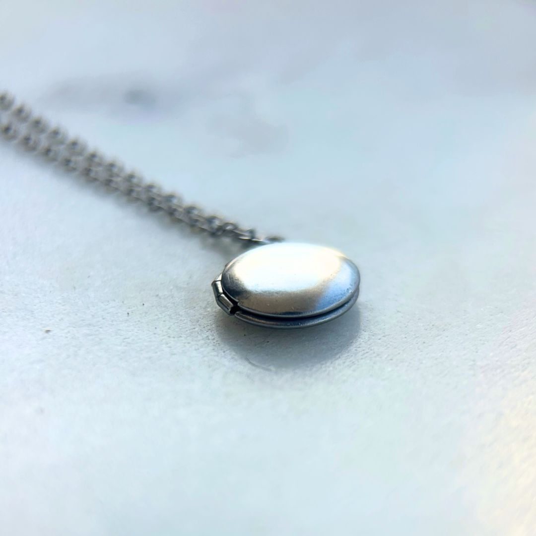 Rest of the Nest mini handprint locket closed on light background