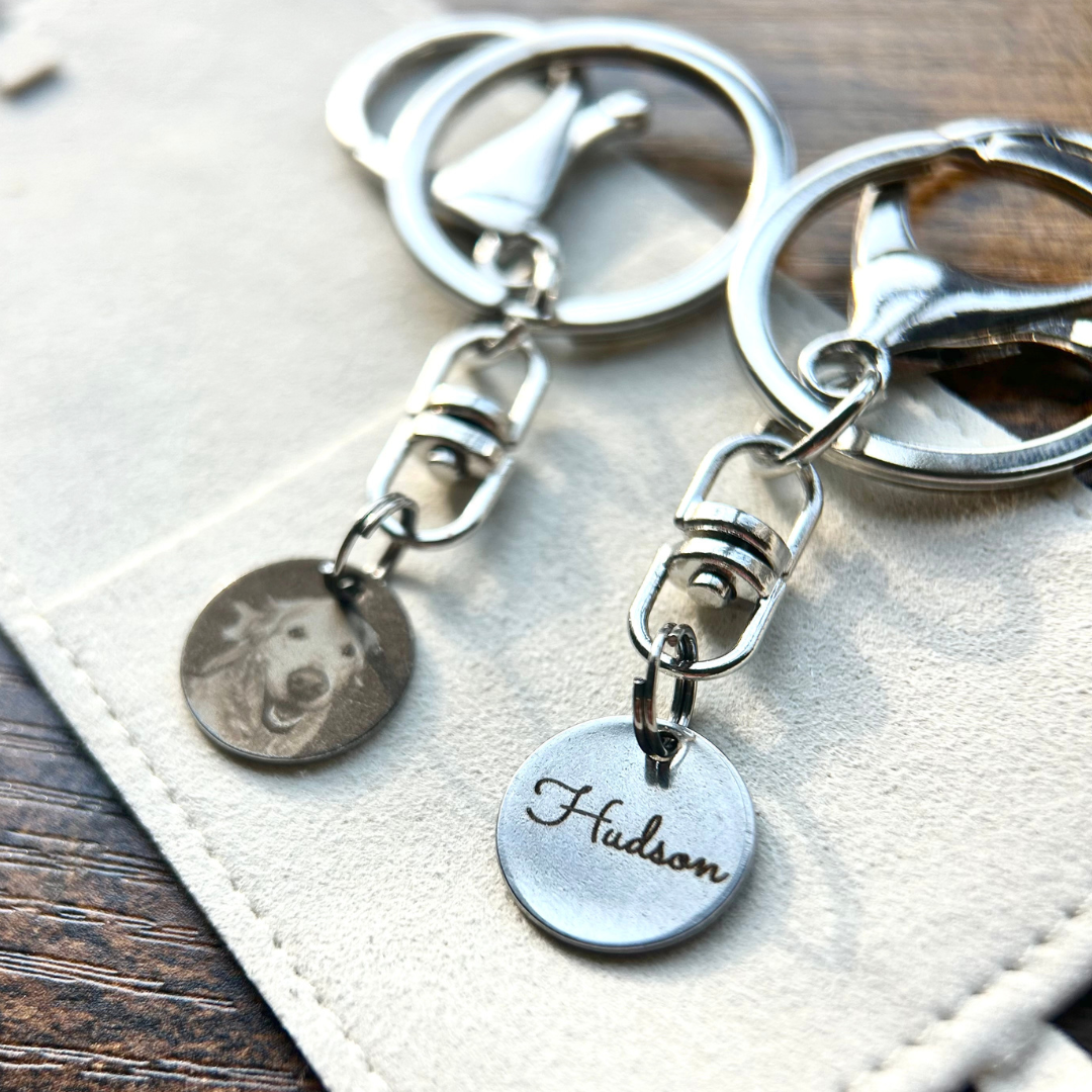 Rest of the Nest silver keychains with dog tag and engraved name on a textured surface