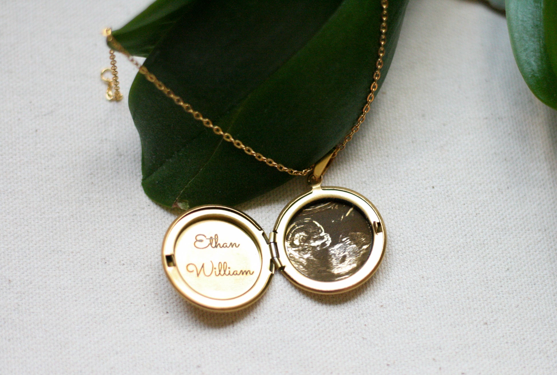 gold locket with sonogram and baby name engraved inside