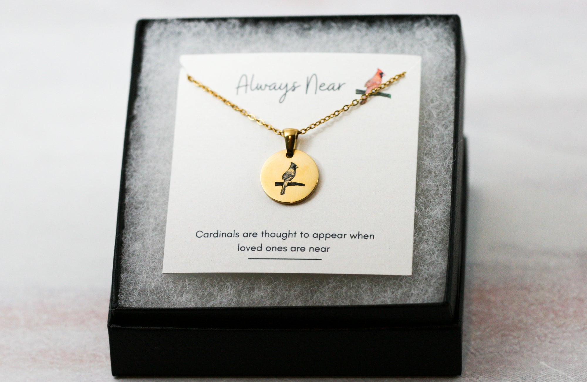 gold cardinal pendant necklace on a card with a cardinal reading 