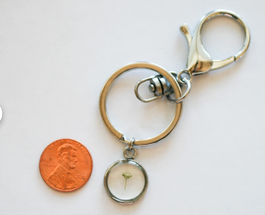 Babys breath silver keychain next to penny for size