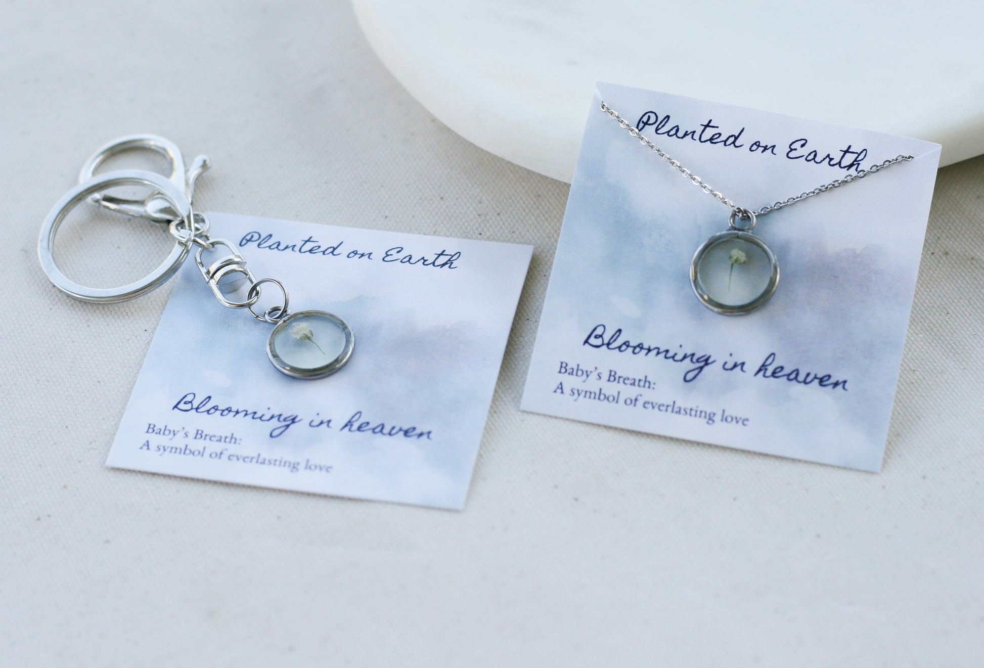 babys breath necklace and keychain in silver on "planted on earth blooming in heaven" cards