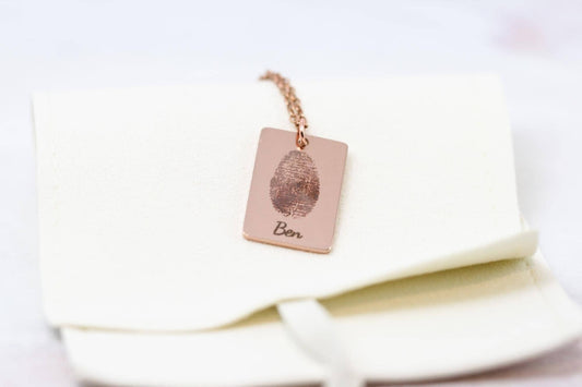 fingerprint engraving necklace with the name "Ben" engraved under the fingerprint on a microfiber necklace bag