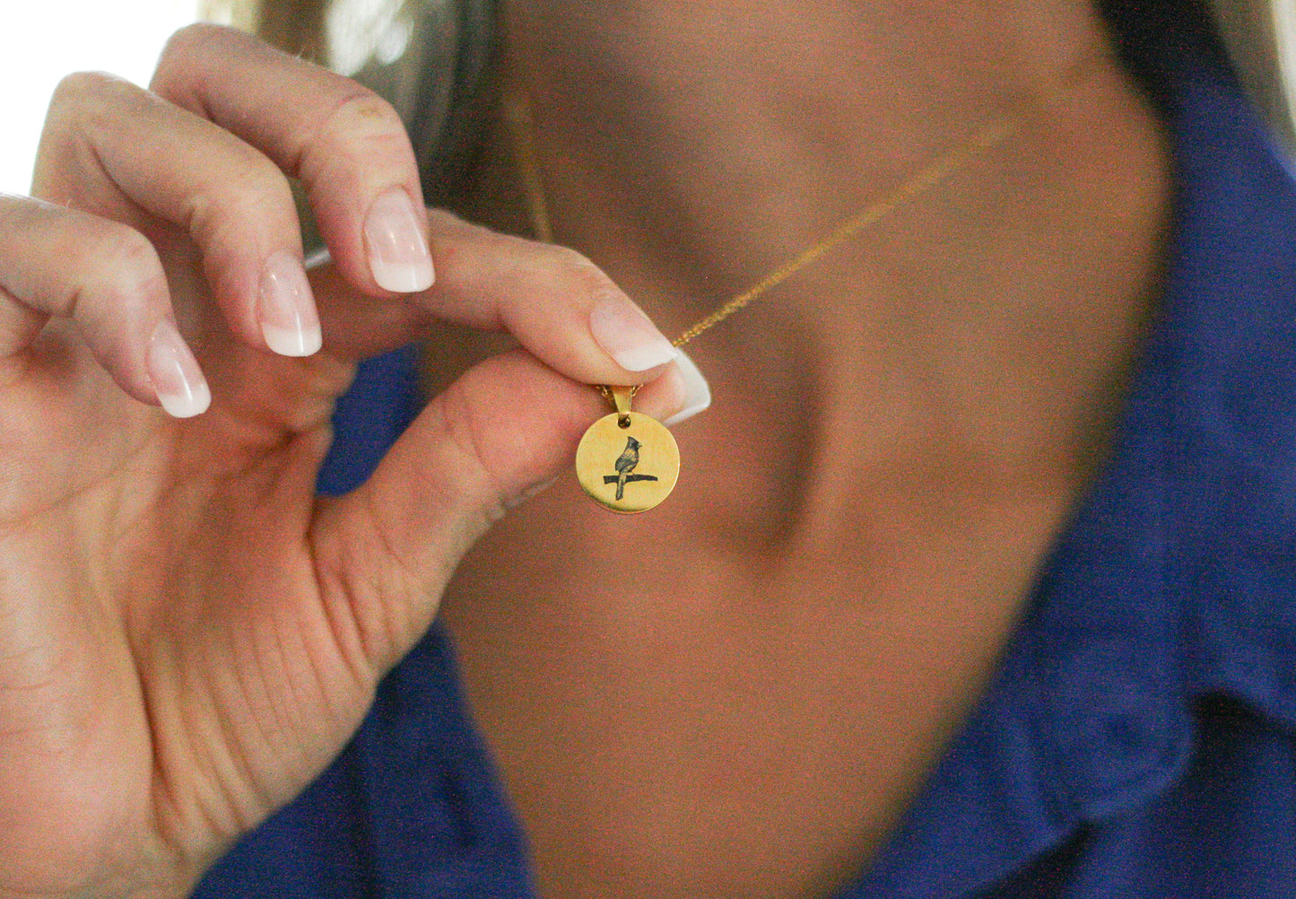 woman wearing a gold cardinal necklace