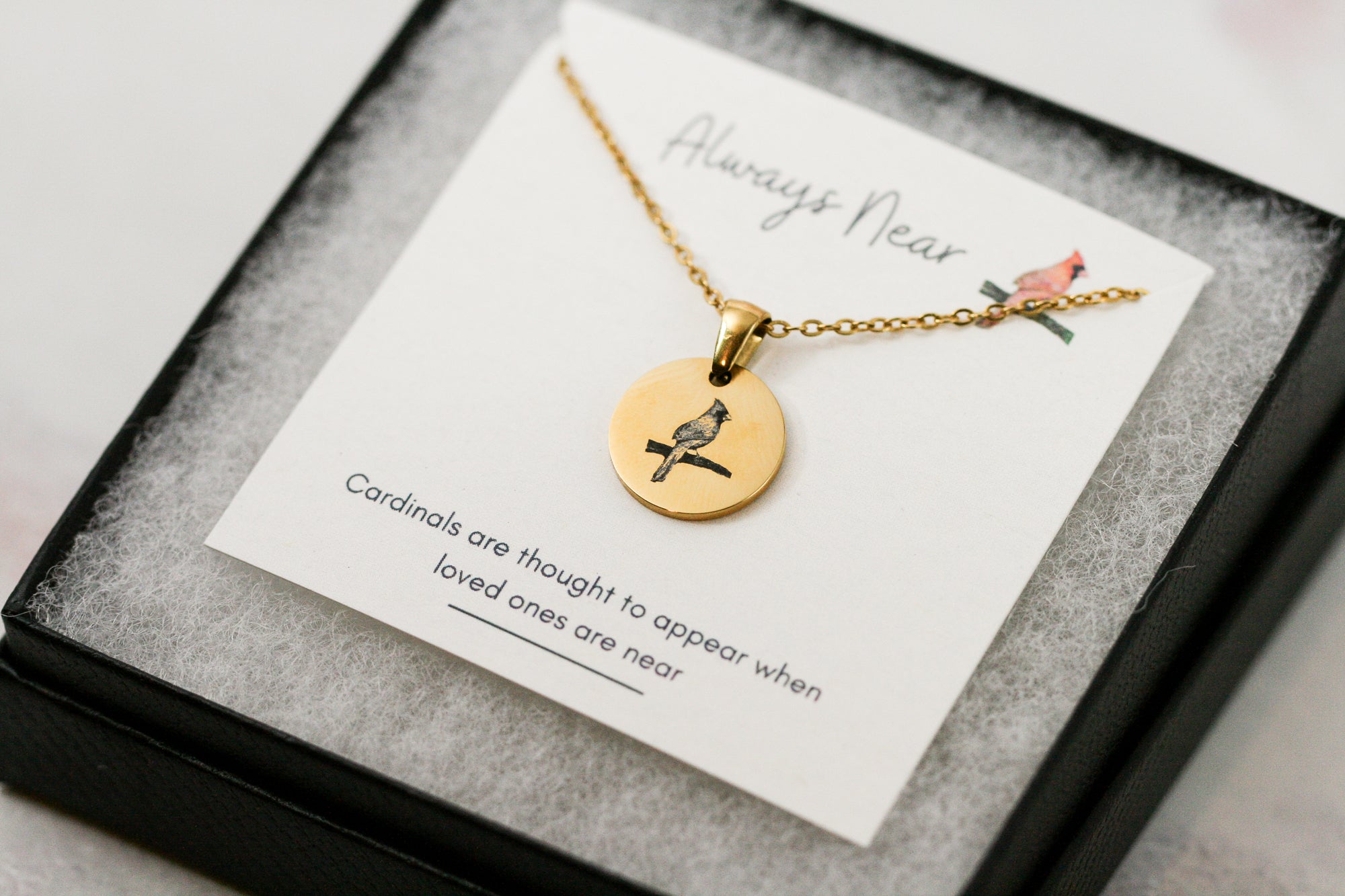 gold cardinal pendant necklace on a card with a cardinal reading 