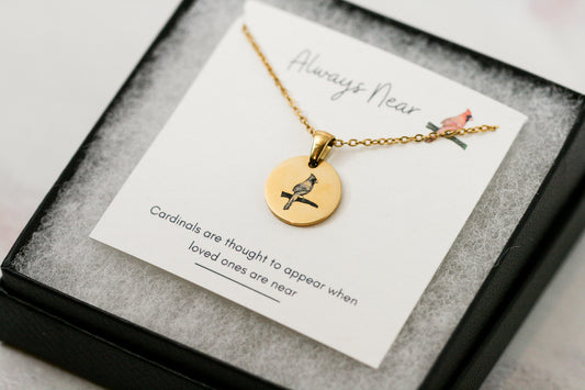 gold cardinal pendant necklace on a card with a cardinal reading "always near" and "cardinals are thought to appear when loved ones are near"