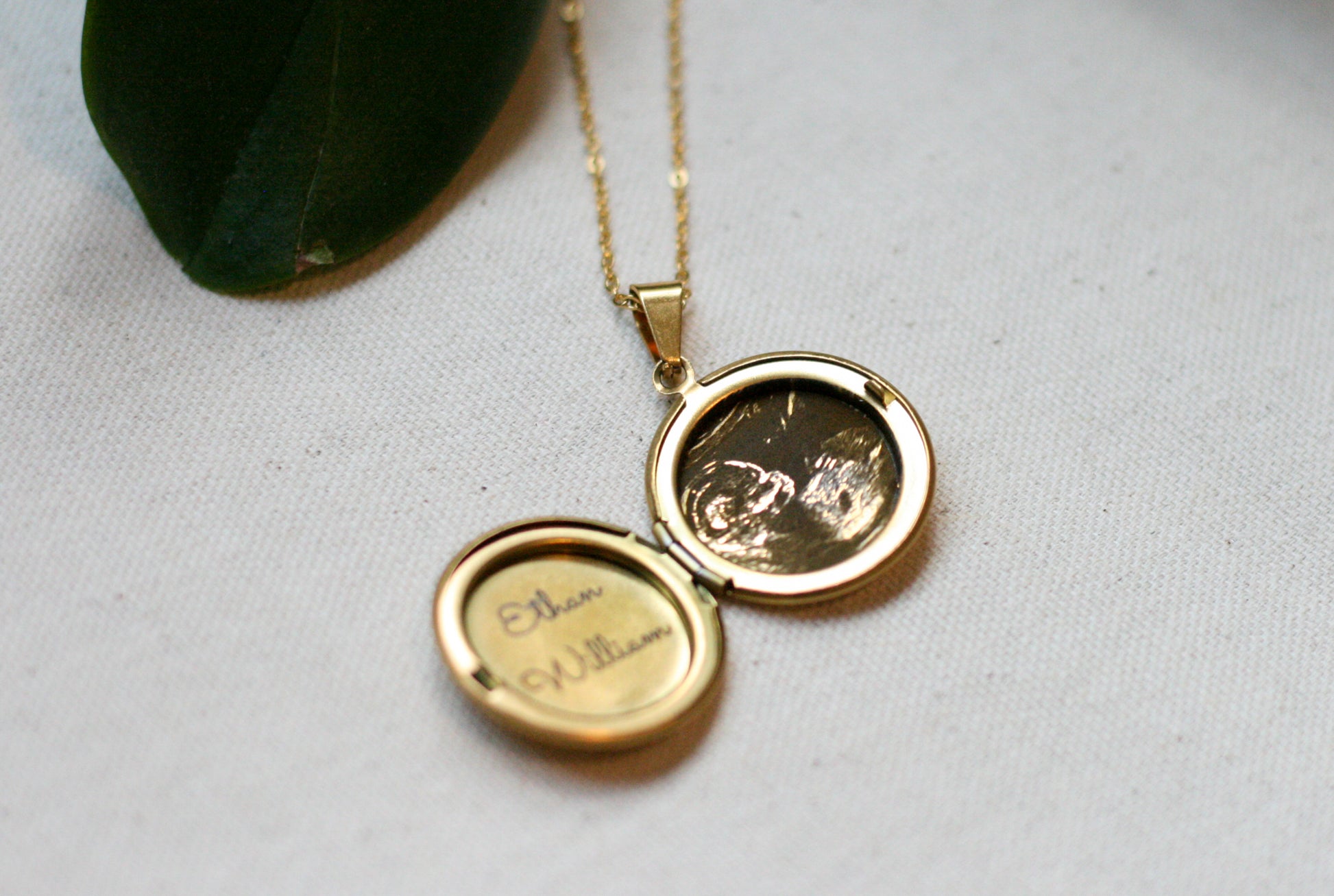 gold locket with sonogram and baby name engraved inside