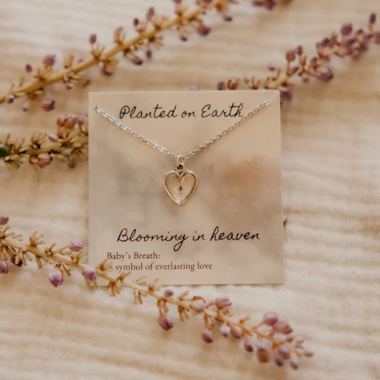 one piece of babys breath in a silver heart pendant necklace on a card reading "planted on earth blooming in heaven"