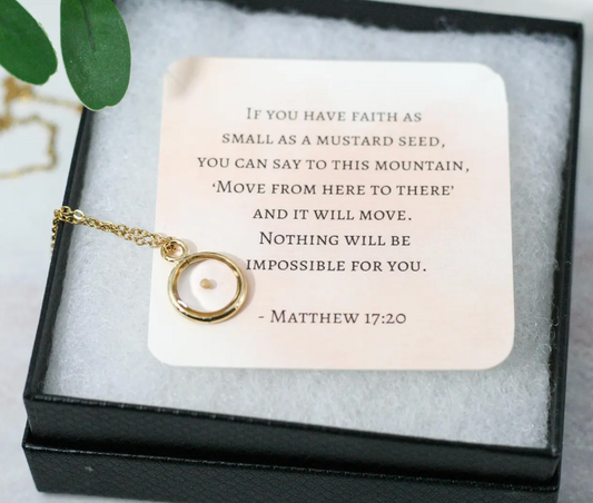 mustard seed necklace in gold on top of card with matthew 17:20 bible verse