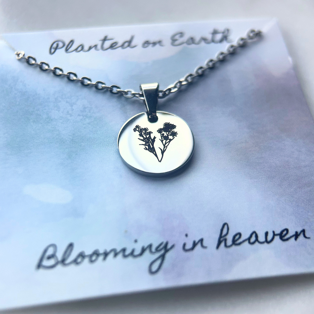 Silver necklace with a circular pendant on a card with text