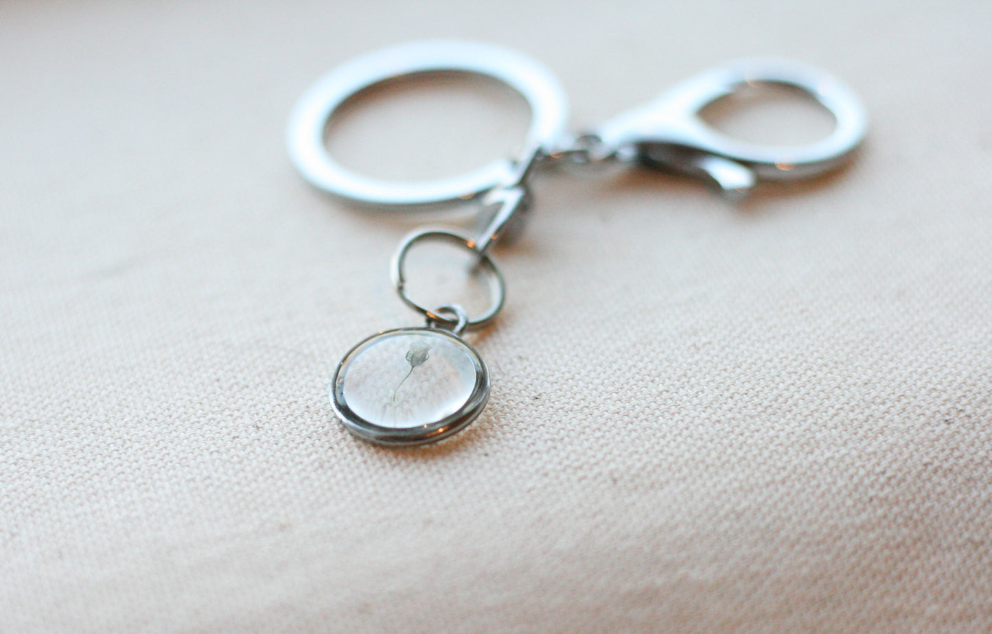 silver keychain with a piece of babys breath inside