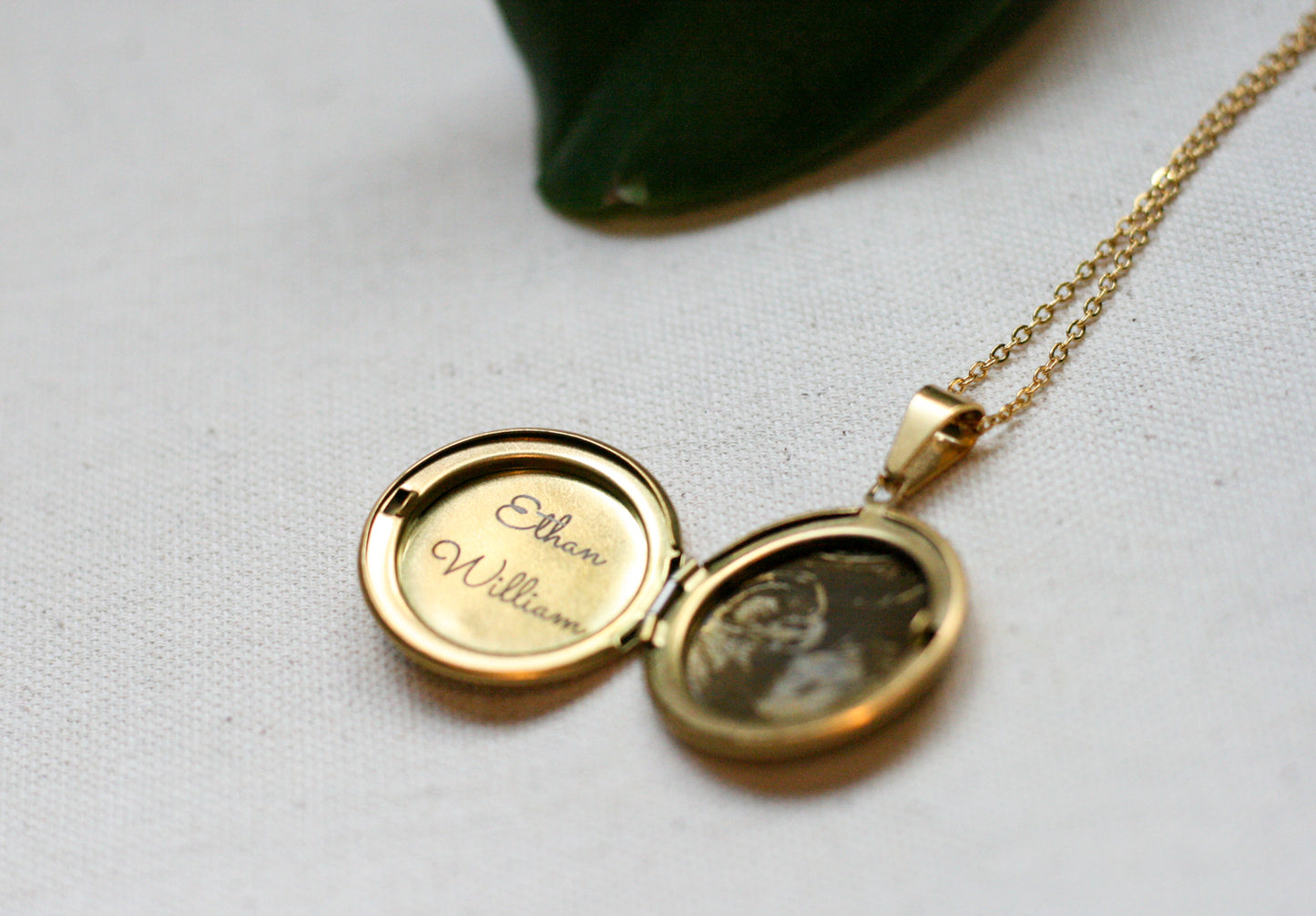 gold locket opened with baby name and sonogram engraved inside